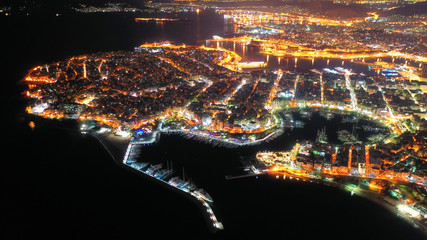 Aerial drone night shot of dazzling illuminated safe port of Marina Zeas with luxury yachts and sailboats docked in the heart of Piraeus, Attica, Greece