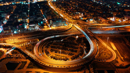 Aerial drone night shot of illuminated ring highway junction near the sea