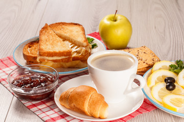 Toasted slices of bread with cheese, apple, cookies and cup of coffee.