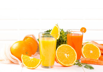 Fresh juices, Orange and carrot drink with fruits and vegetable on wooden table. 