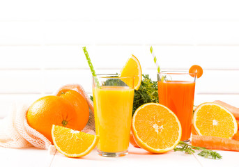 Fresh juices, Orange and carrot drink with fruits and vegetable on wooden table. 