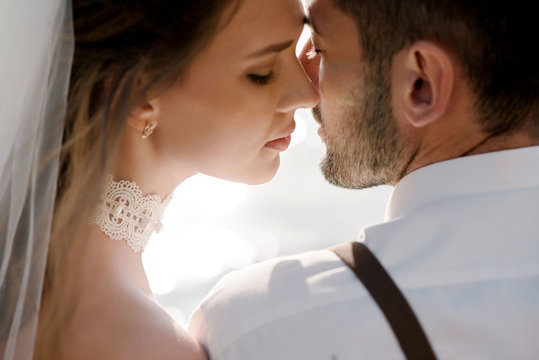 Close up romantic sensual wedding couple of groom and bride kissing outdoors.