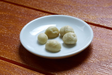 Fototapeta na wymiar Top view of macadamia nuts in bowl on wooden background.