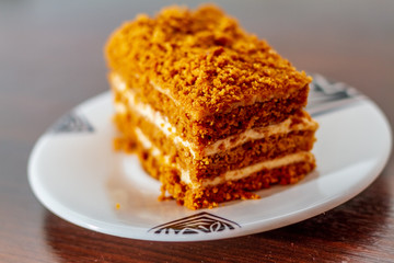 Honey cake piece on a dark wood table isolated