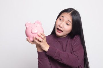 Young Asian woman with a pig coin bank.