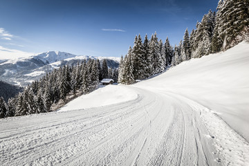 Skiweg im Winter unter blauem Himmel mit Panorama