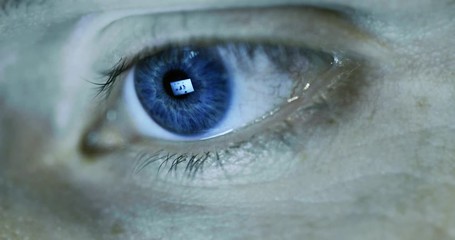 human eye pupil closeup with computer screen reflection