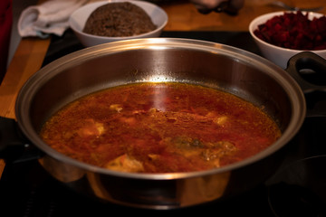 cook preparing lamb soup with vegetables in the kitchen