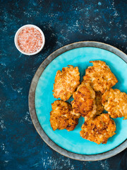 Homemade fried chicken cutlets, fillet nuggets in ceramic plate on dark blue background. Diet concept. Healthy food. Flat lay