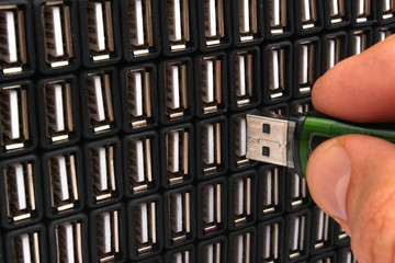 Hand inserting USB flash drive in one of many sockets