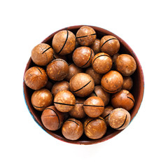 macadamia nuts in bowl on white background, top view