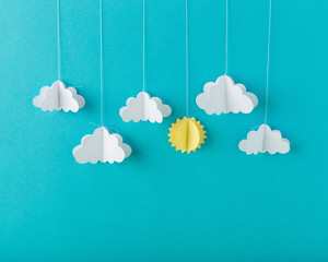 Blue background paper with white clouds on a string, minimalism