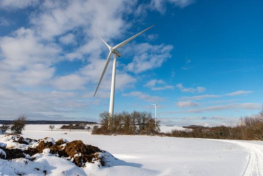 Grande éolienne dans un paysage en hiver avec de la neige sur fond de ciel bleu en Moselle