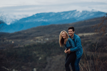 Naklejka premium Couple family traveling together on cliff edge. man and woman lifestyle. concept summer vacations outdoor view mountain top. on blue mountains background