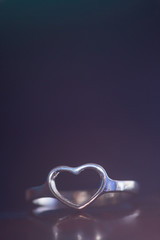 Silver heart shape ring with purple background