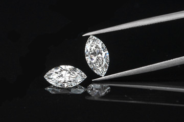 marquise diamond with tweezer on black background