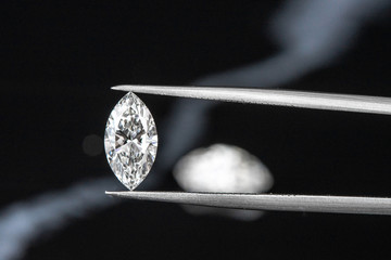 marquise diamond with tweezer on black background