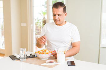 Fototapeta na wymiar Middle age man eating asian food at home