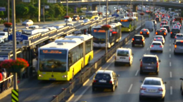 Out of focus. Insane rush hour traffic jam in Istanbul Metro Bus Line. High speed public buses moving on in-city express way. Incirli bus stop with yellow buses