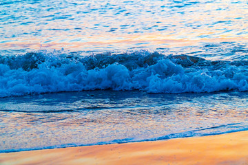 Welle im romantischen Abendrot am Strand auf Hawaii