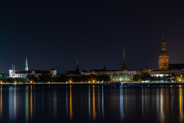 Fototapeta na wymiar Panoramic night view on old Riga the capital of Latvia city from left bank of Daugava river. Its unique with a medieval and Gothic architecture.