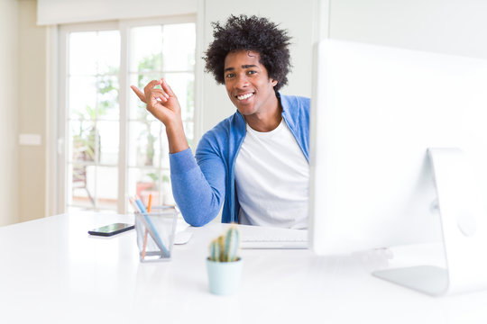 African American man working using computer very happy pointing with hand and finger to the side