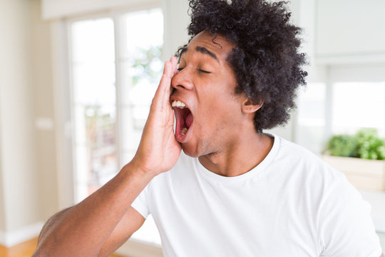 African American man wearing white t-shirt shouting and screaming loud to side with hand on mouth. Communication concept.