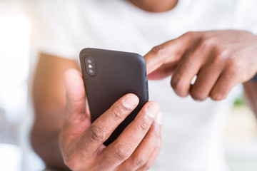 Close up of african american man hands using smartphone