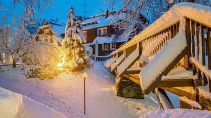 Papier Peint photo autocollant Le pont de la Bastei Brücke aus Holz mit Haus in der Nacht mit Licht im schnee in Nationalpark der sächsische schweiz, Elbsandsteingebirge an der Bastei brücke, Deutschland.