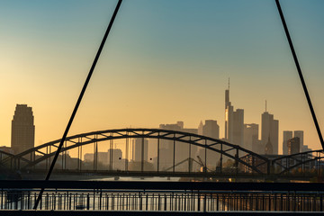 Obraz premium Skyline von Frankfurt am Main bei sonnenuntergang hinter Brücken