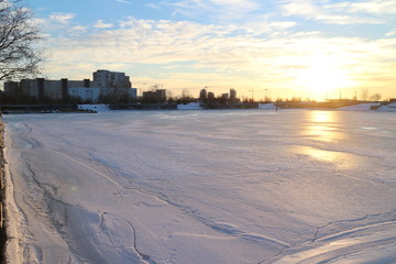 sunsets on city pond in winter