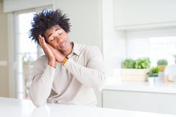 African American man at home sleeping tired dreaming and posing with hands together while smiling with closed eyes.