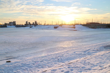 sunsets on city pond in winter