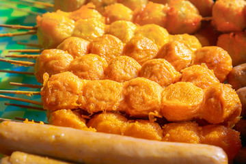 Traditional Asian food on wooden skewers, baked on the grill - satay on the tables of street trading. Close-up
