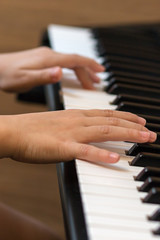 Obraz premium Hands of the child on the piano keys. Selective focus.