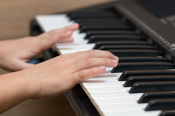 Fototapeta na wymiar Hands of the child on the piano keys. Selective focus.