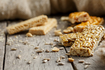 Assorted kozinaki, on old vintage background, with burlap fabric. Country style. Delicious sweets from the seeds of sunflower, sesame and peanuts, covered with shiny glaze.