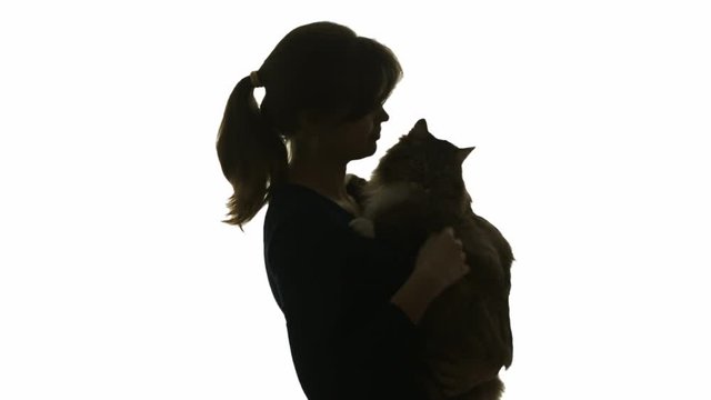 silhouette profile of a young woman holding a cat in her arms, a girl stroking a pet with love and hugging on a white isolated background