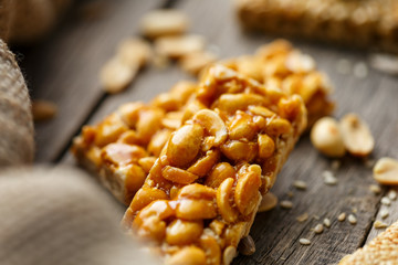 Assorted kozinaki, on old vintage background, with burlap fabric. Country style. Delicious sweets from the seeds of sunflower, sesame and peanuts, covered with shiny glaze.