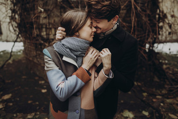 romantic stylish couple hugging gently in autumn park. man and woman embracing, showing true...