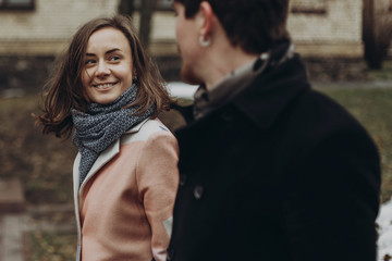 romantic stylish couple walking and laughing in autumn park. man and woman having fun and talking....