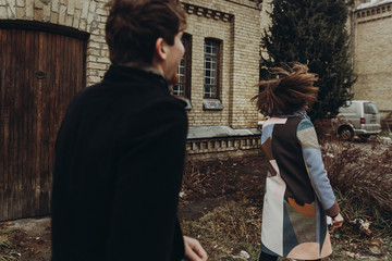 stylish couple having fun and laughing in autumn park. man and woman running and playing, joyful moments of true happiness. family togetherness concept.  atmospheric