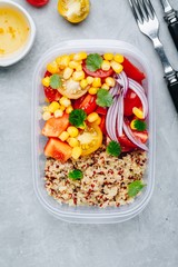 Healthy vegan meal prep containers with quinoa and fresh vegetables