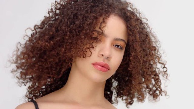 slow motion from 60 fps hair blowing closeup portrait of mixed race model with freckles touches her neck and face