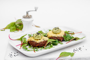 Cutlets on a white plate. Cheese, sauce, greens. White background. Decor.