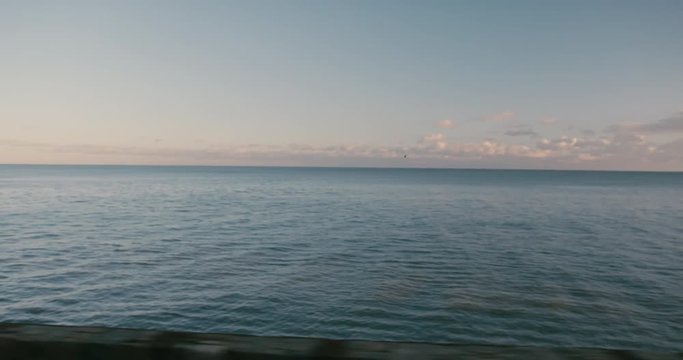 View of the sea at sunset from moving train