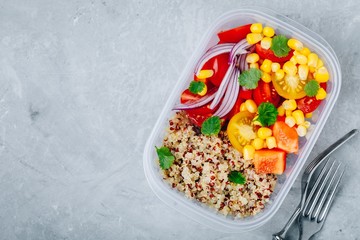 Healthy vegan meal prep containers with quinoa and fresh vegetables