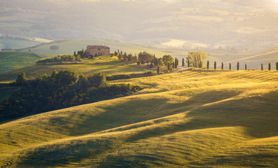 Fototapeta premium A lonely farmhouse between tuscan rolling hills. Val d'Orcia, Siena province, Tuscany, Italy