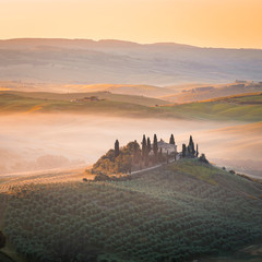 Obraz premium A lonely farmhouse between tuscan rolling hills. Val d'Orcia, Siena province, Tuscany, Italy