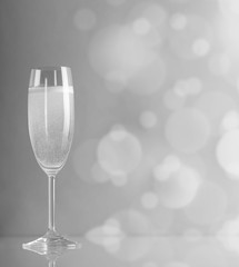 Glass of champagne in a black-and-white color against the bright circles